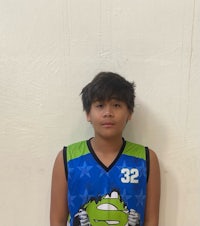 a young boy in a basketball uniform posing for a picture