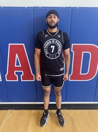 a man in a basketball uniform standing in front of a wall