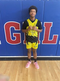 a young man standing in front of a basketball court