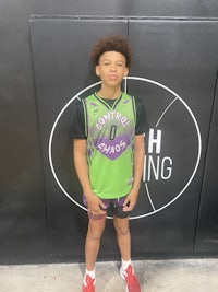 a young man standing in front of a basketball court