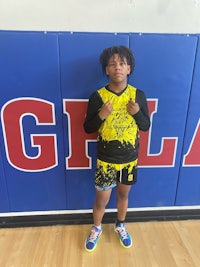 a young boy standing in front of a gym with a sign