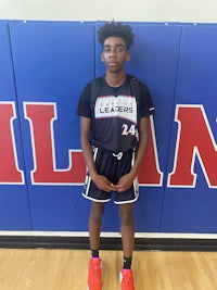 a young man standing in front of a basketball court