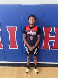 a young man standing in front of a basketball court