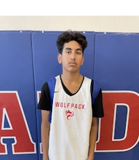 a young man standing in front of a basketball court