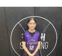 a girl in a basketball uniform standing in front of a wall