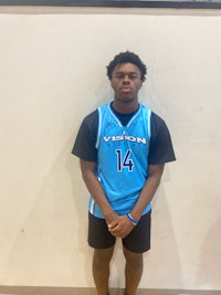 a young man in a blue uniform standing in front of a wall