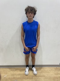 a young boy wearing a blue shirt and blue shorts