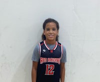 a young girl in a basketball uniform posing for a picture