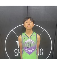 a young man in a basketball uniform standing in front of a wall