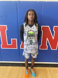 a young man in a basketball uniform standing in front of a wall