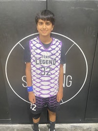 a young boy standing in front of a basketball court