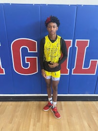 a young man standing in front of a basketball court