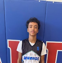 a young man in a basketball uniform standing in front of a wall