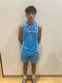 a young man in a blue basketball uniform standing in front of a wall